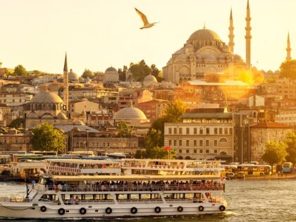 Tourist boat floats on the Golden Horn in Istanbul at sunset